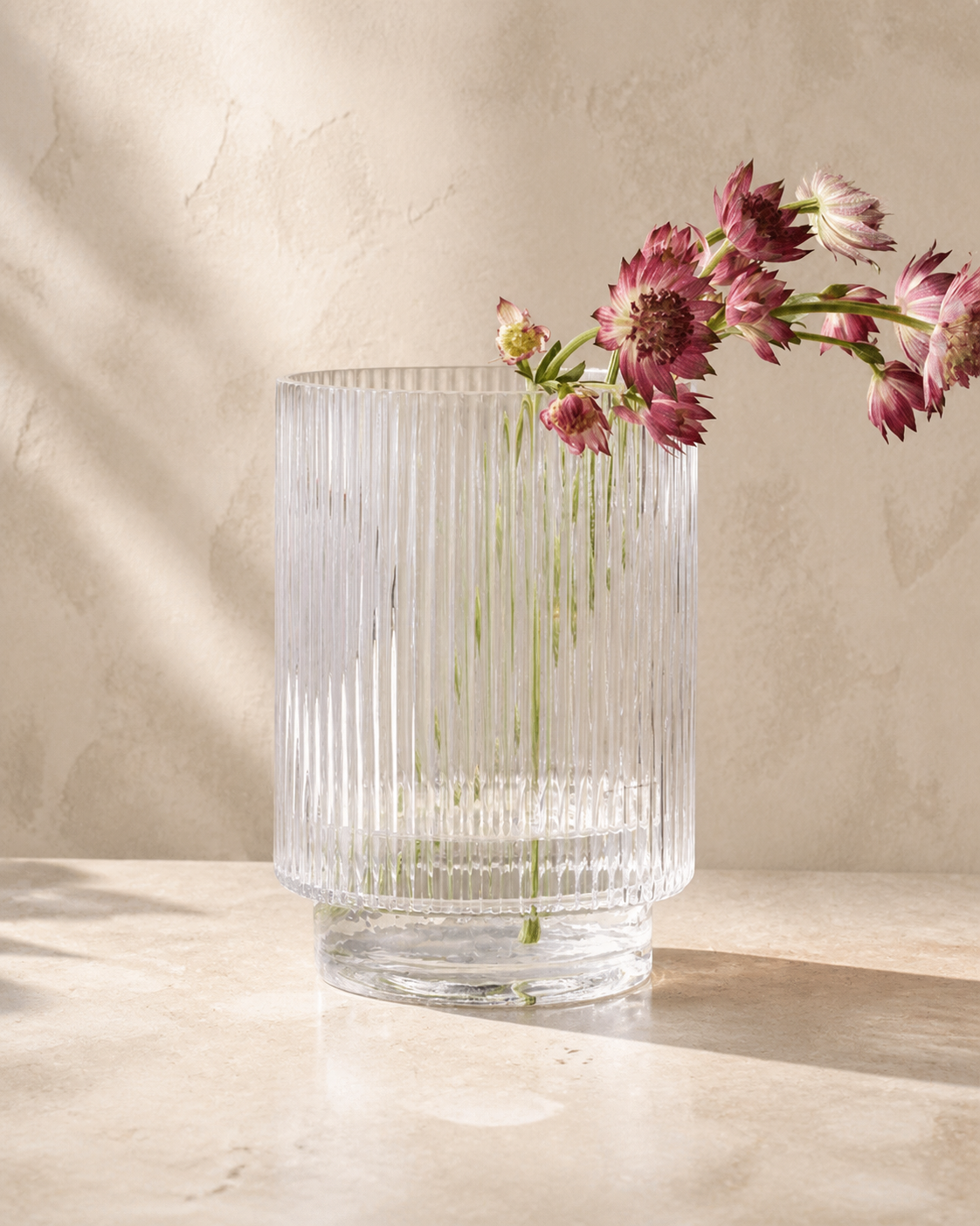 Dina Fluted Glass Vase with flowers in warm architectural studio light