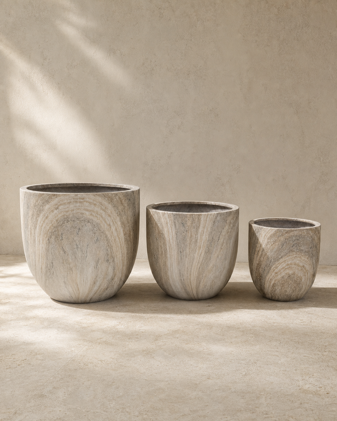 Eco Stone Oversized Travertine Planter Set of three in warm architectural studio light