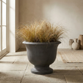 Cairn Round Pedestal graphite cast concrete pedestal planter with ornamental grasses