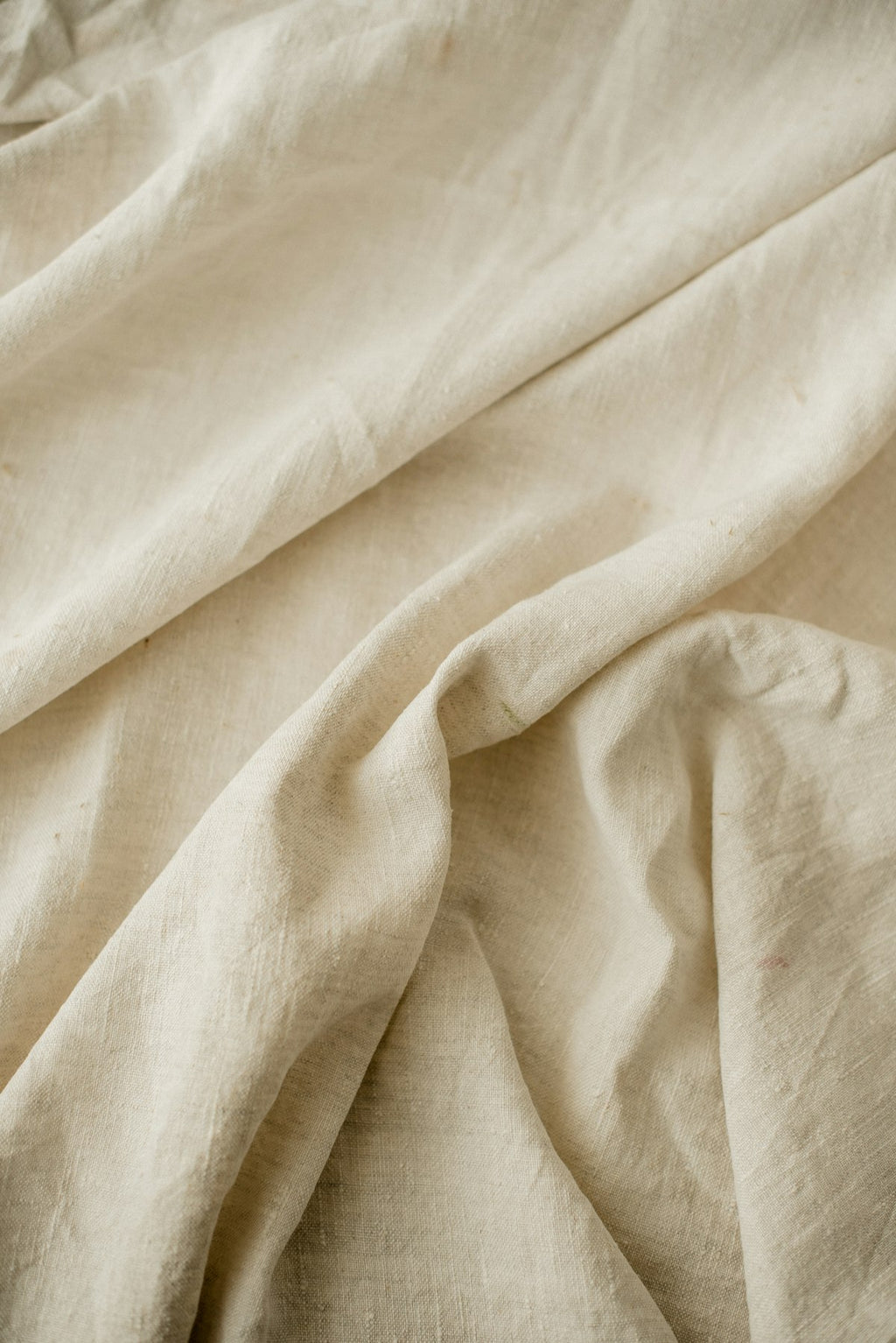 Neutral linen throw blanket draped over modern chair
