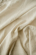 Neutral linen throw blanket draped over modern chair