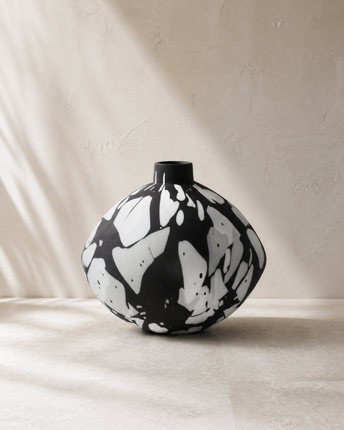 Aleksi matte black patterned glass vase in a warm plaster studio.
