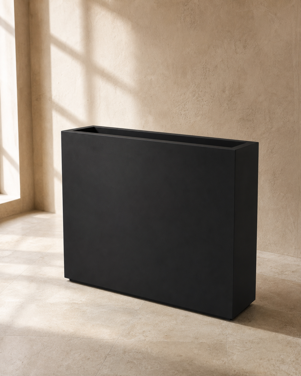 Matte black span outdoor divider planter against warm limewashed plaster.