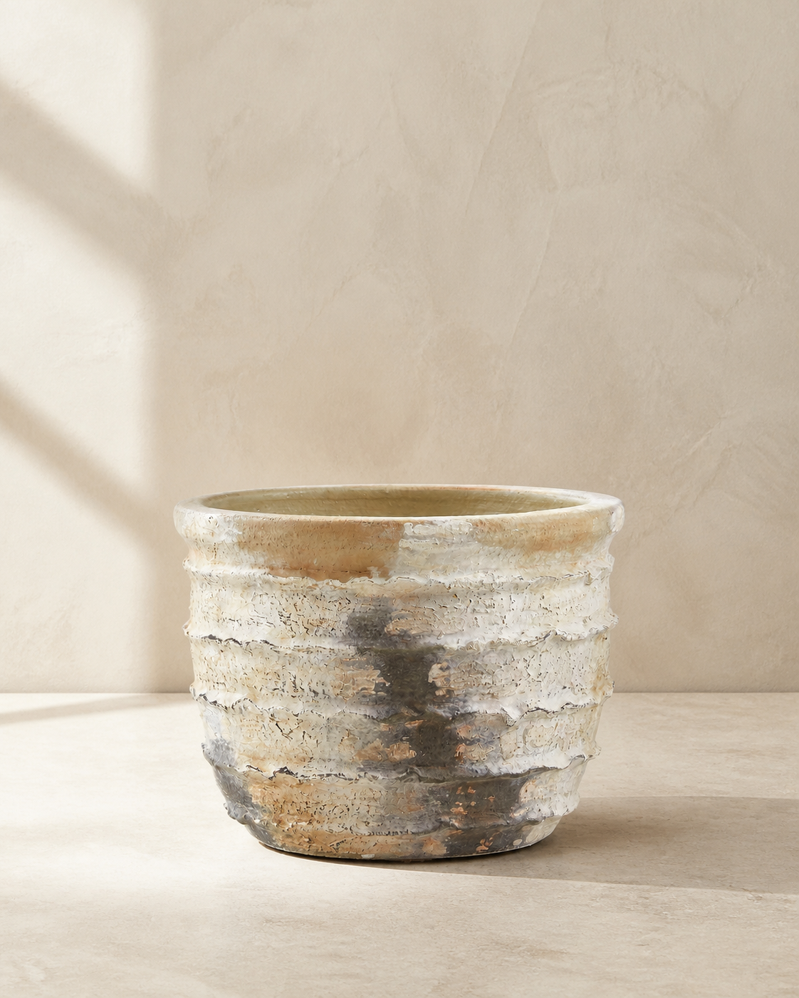 Weathered hand-painted terracotta outdoor planter with a layered neutral finish.