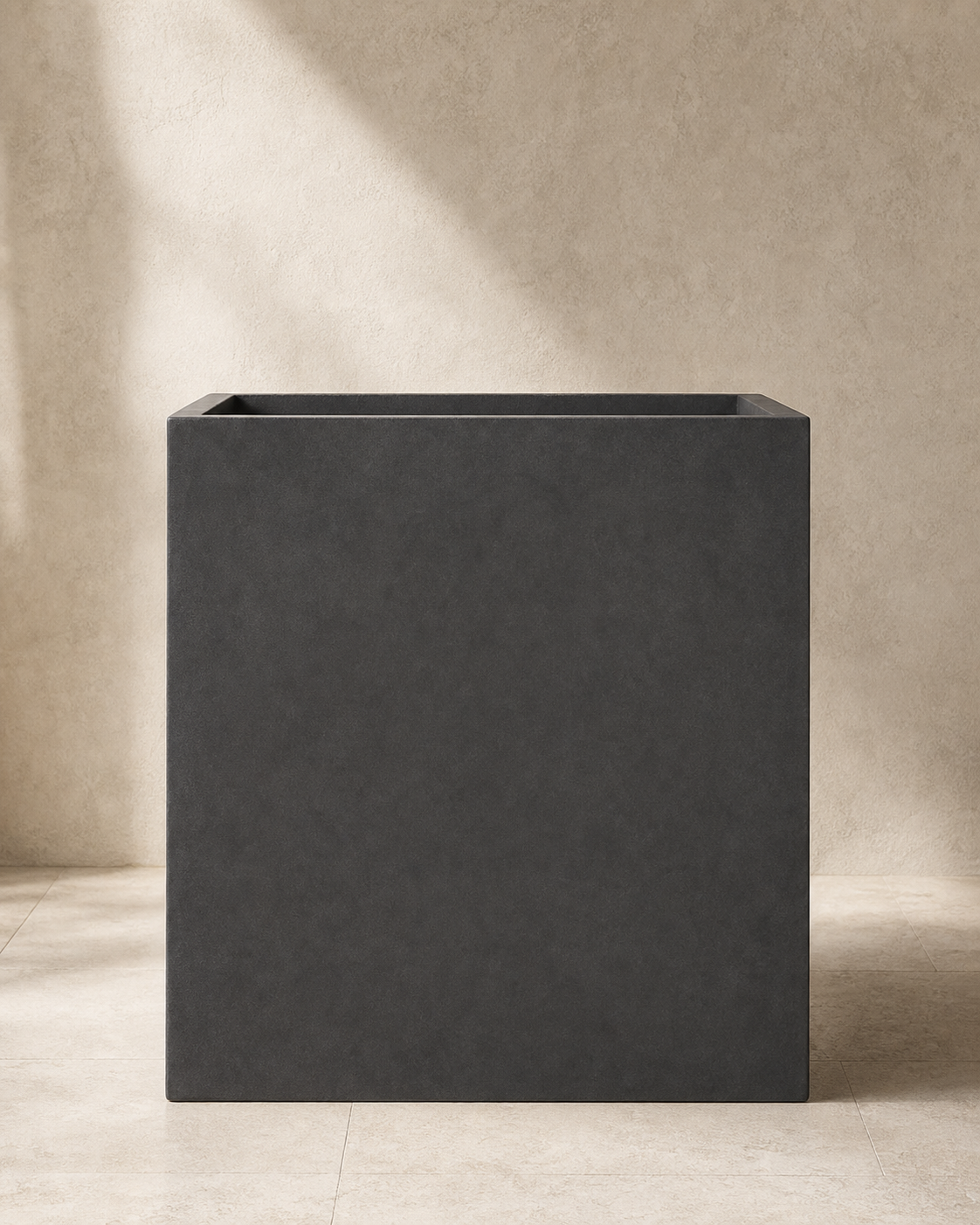 Dark gray Ash rectangular concrete outdoor planter in a warm plaster studio.