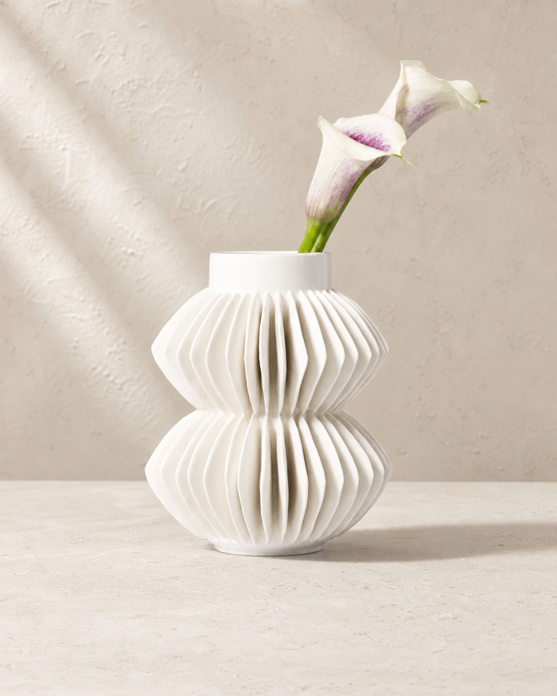Celia white porcelain ribbed bud vase with two pale calla stems.