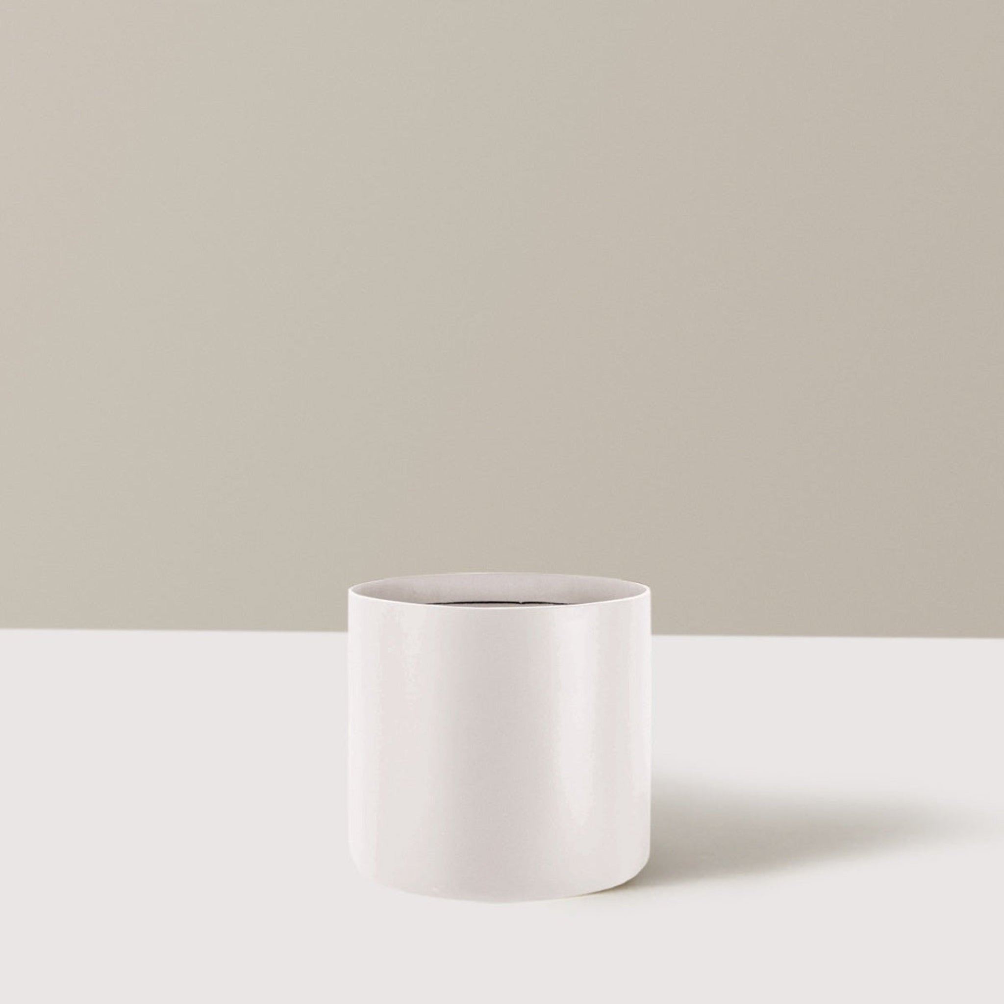 White cylindrical pot on a light beige background